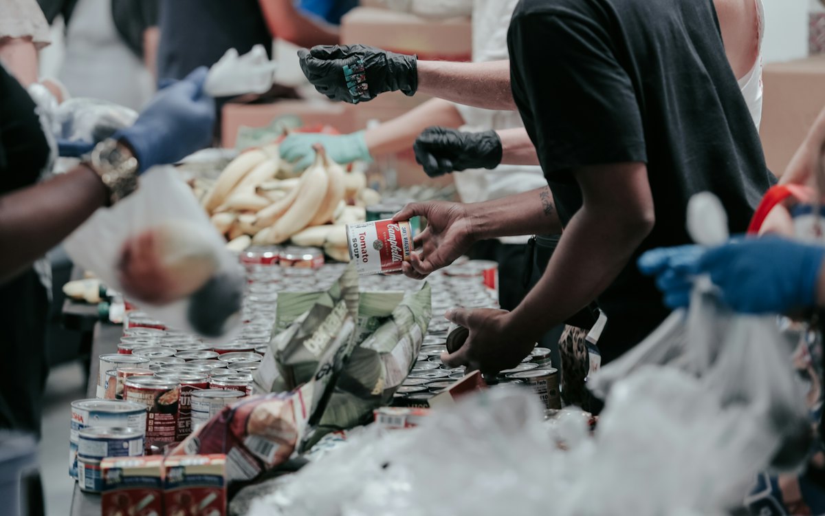 Volunteers sorting canned food donations at a long table